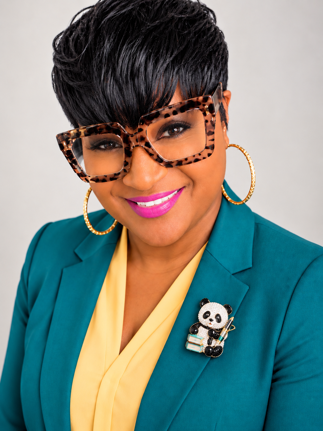 Kimi Johnson, publisher and book coach, in a teal blazer and yellow top
